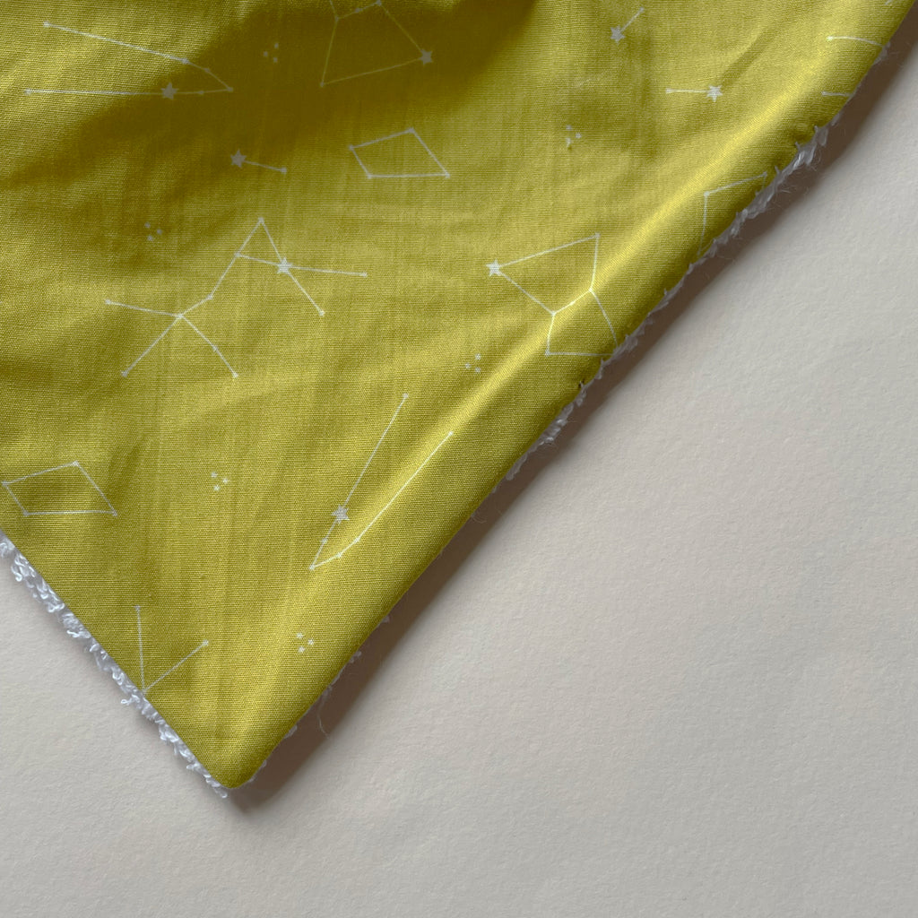 détail du motif du mini bavoir bandana pour les dents de bébé motif constellations sur fond jaune moutarde Carotte & Cie