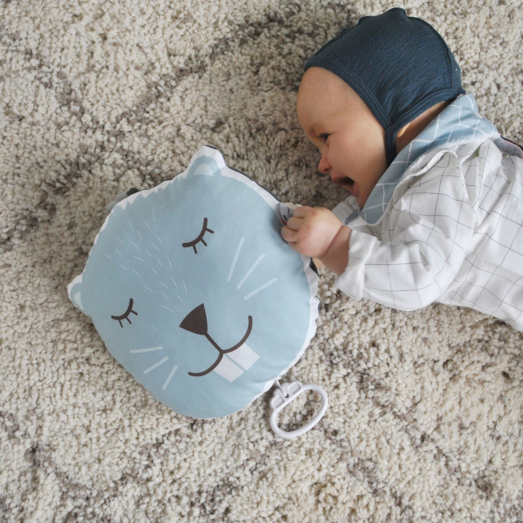 ambiance d'un bébé jouant avec un coussin musical illustré motif exclusif tête de castor bleu céladon Carotte & Cie