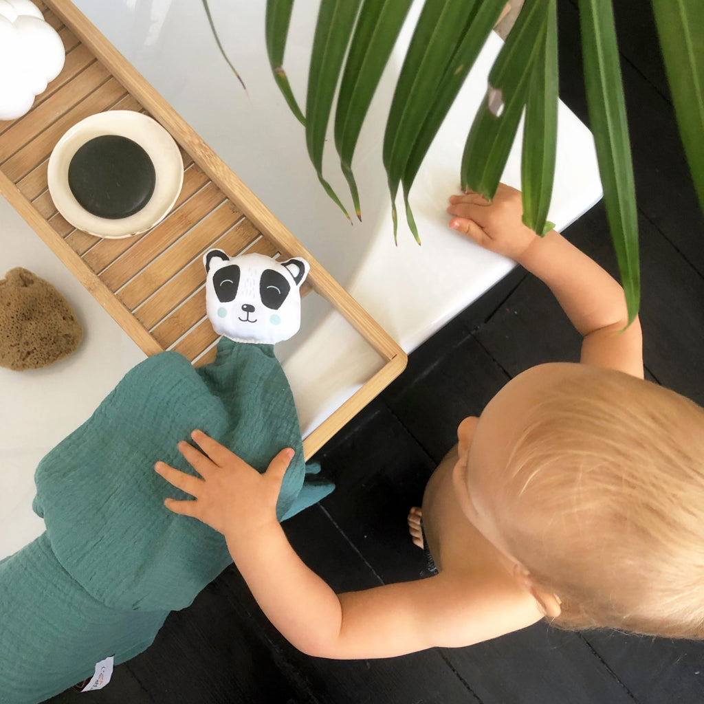 bébé joue avec son doudou plat en lange de coton panda noir et blanc et lange de coton vert eucalyptus motif exclusif Carotte & Cie