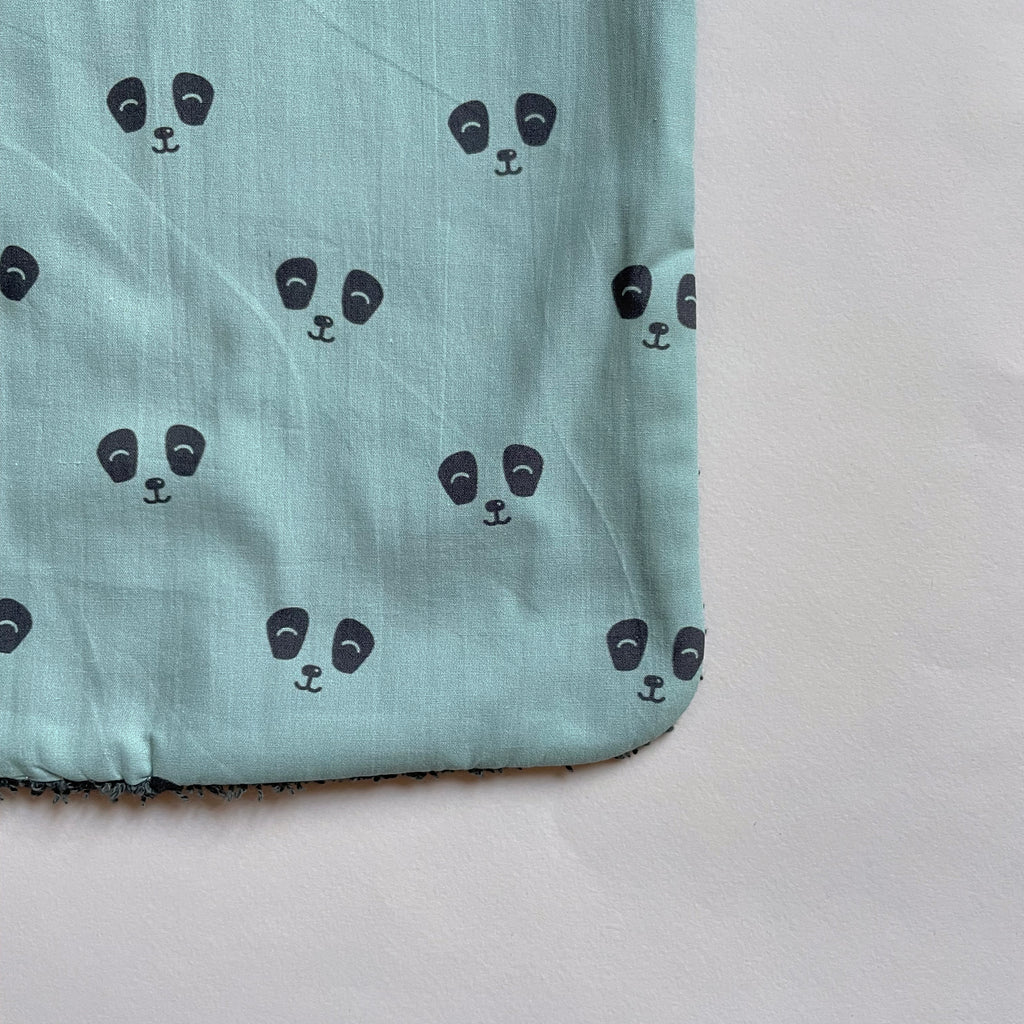 détail du motif du bavoir pour les repas de bébé motif exclusif panda gris sur fond vert pastel Carotte & Cie
