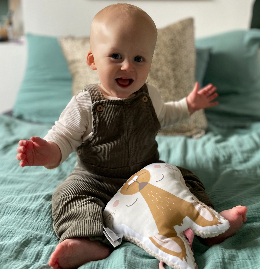 bébé est heureux de jouer avec son mini coussin musical écureuil beige et camel Carotte & Cie