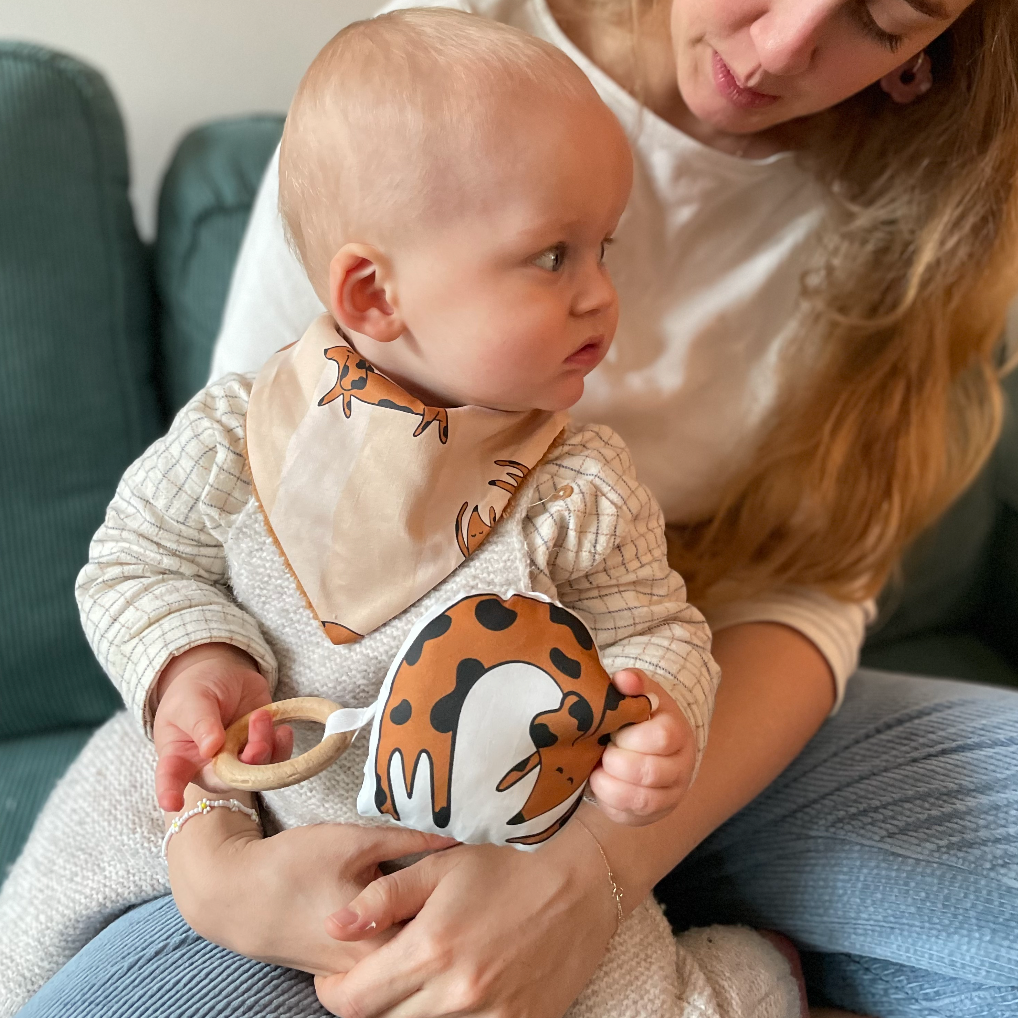 bébé joue avec son anneau de dentition en bois et coton bio motif chien teckel chocolat Carotte & Cie