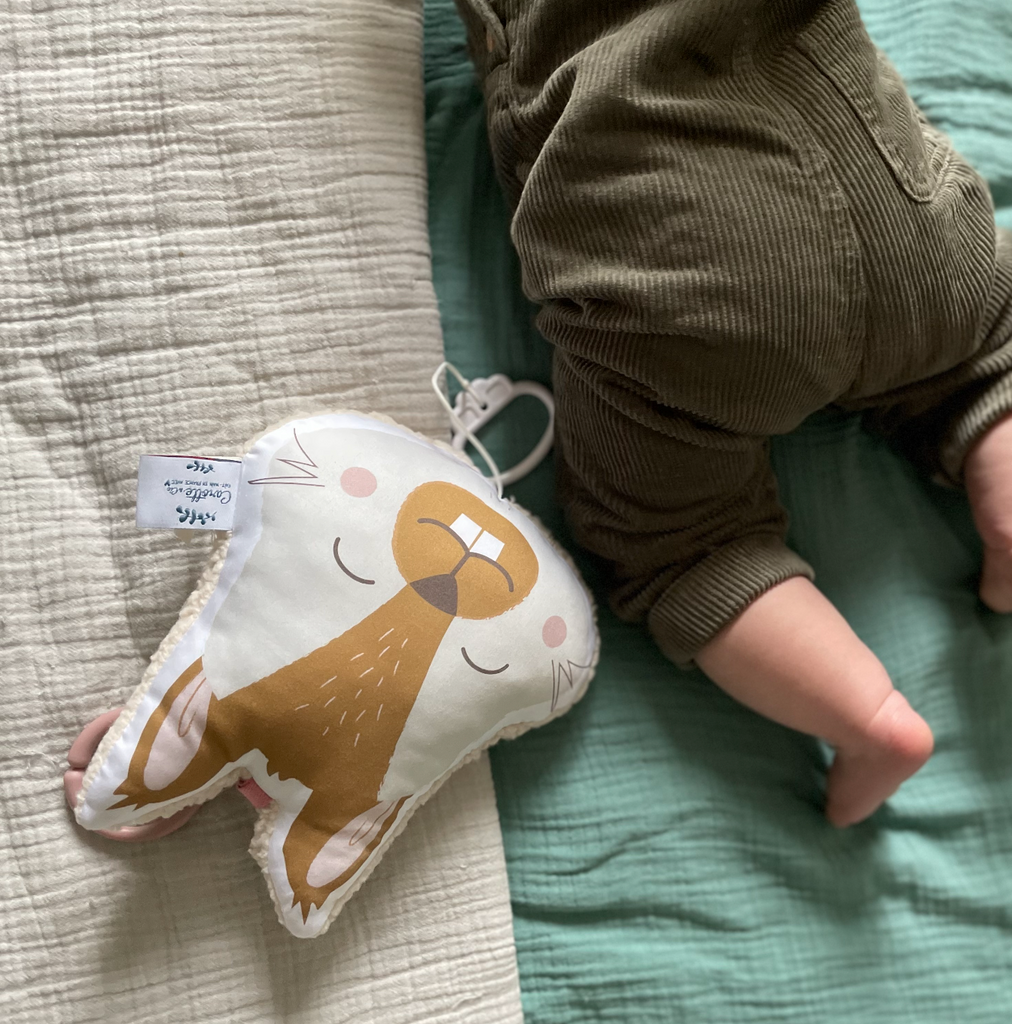 bébé joue avec son mini coussin musical écureuil camel et beige Carotte & Cie