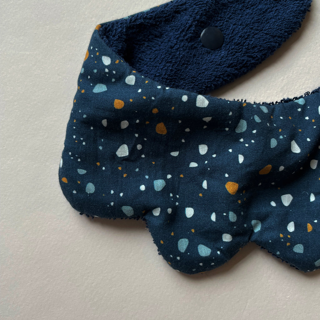 détail du motif du mini bavoir forme fleur pour les dents de bébé motif granite fond bleu marine Carotte & Cie