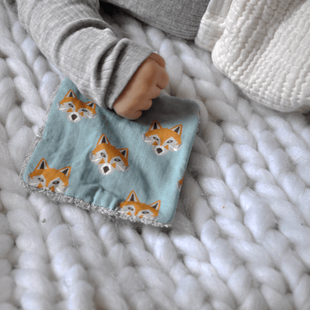 Bébé est posé sur une lingette renard bleu Carotte & Cie