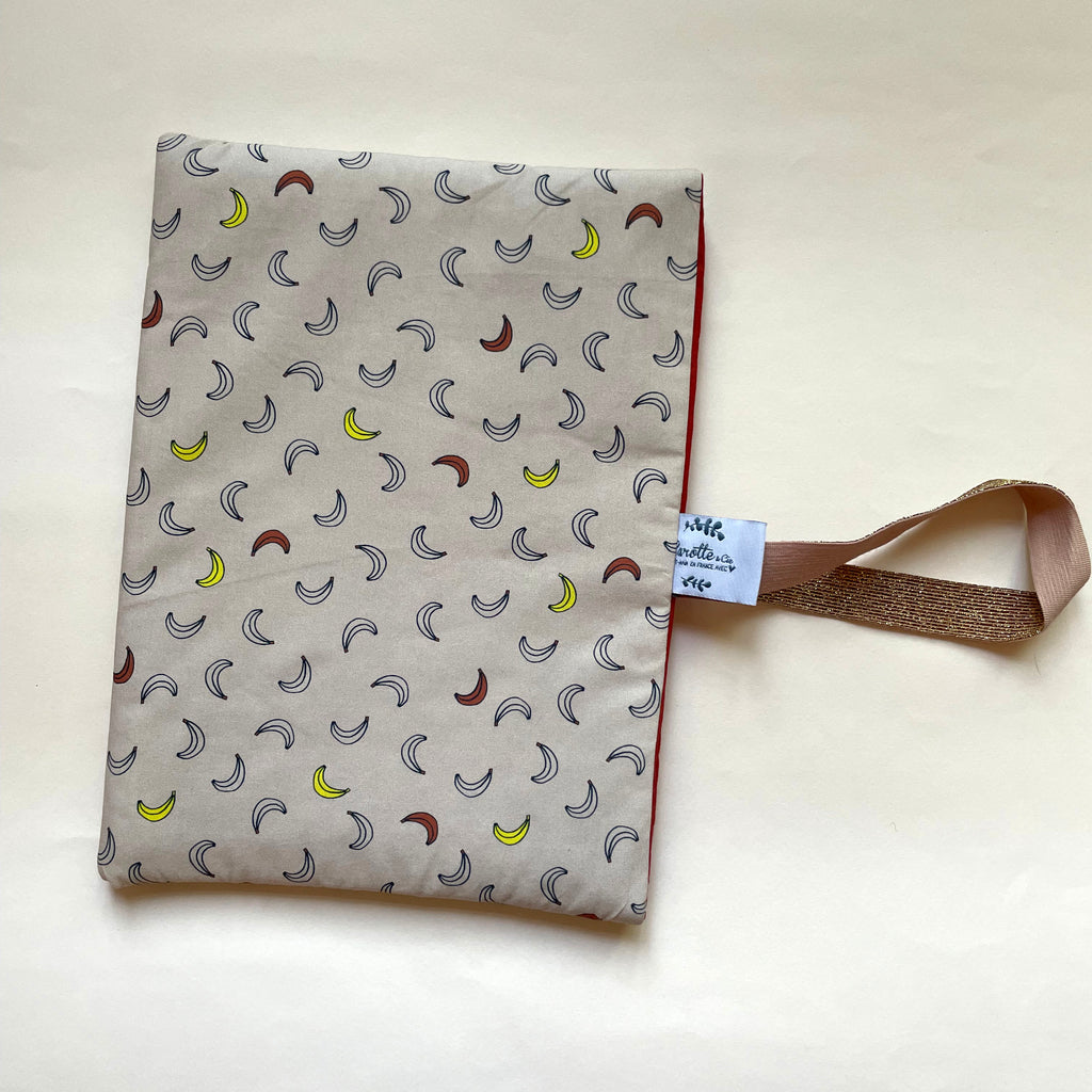 Pochette de protection pour livre format broché rembourrée et avec un élastique de maintien; Motif Banana fond beige dessiné et fabriqué avec amour par Alexandra ,créatrice de Carotte & Cie. Idéal cadeau de fête des mères.