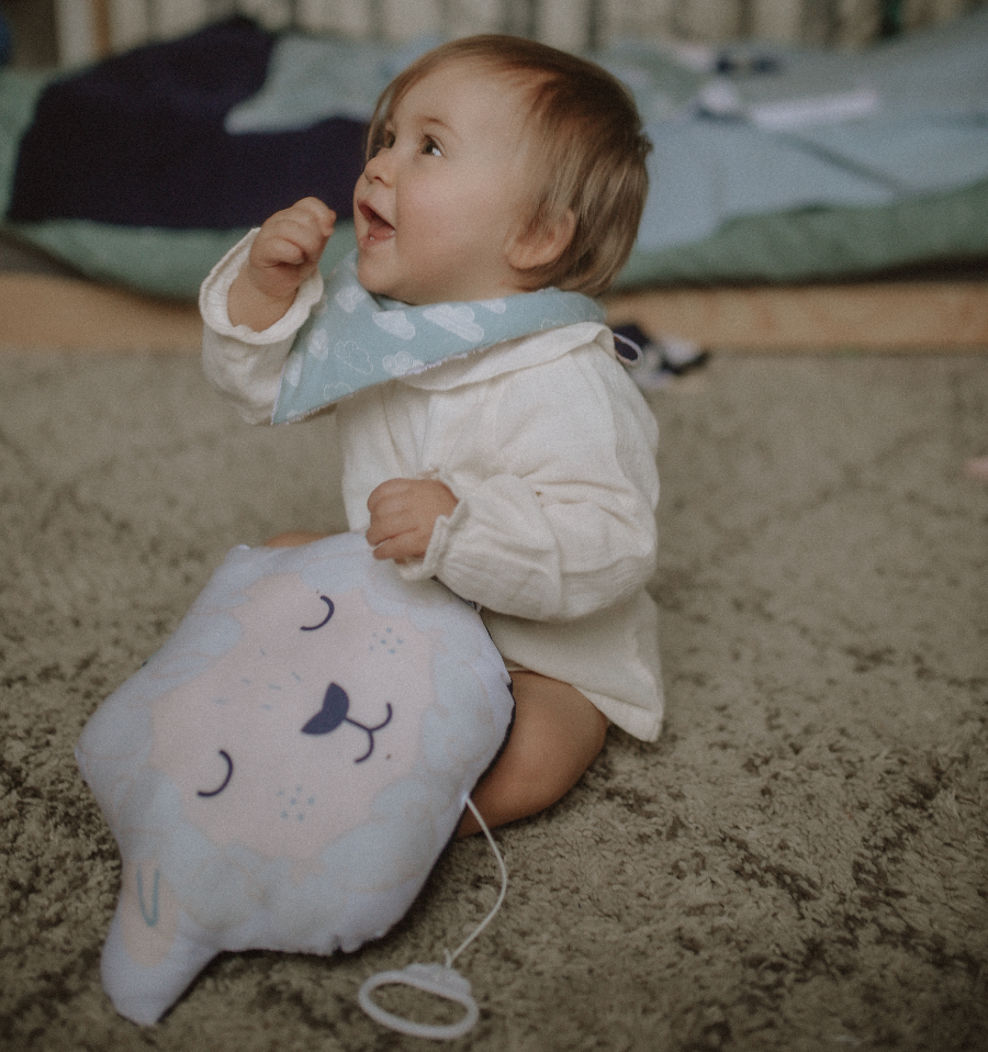 bébé porte un mini bavoir bandana pour les dents de bébé motif nuages blancs sur fond bleu céladon Carotte & Cie