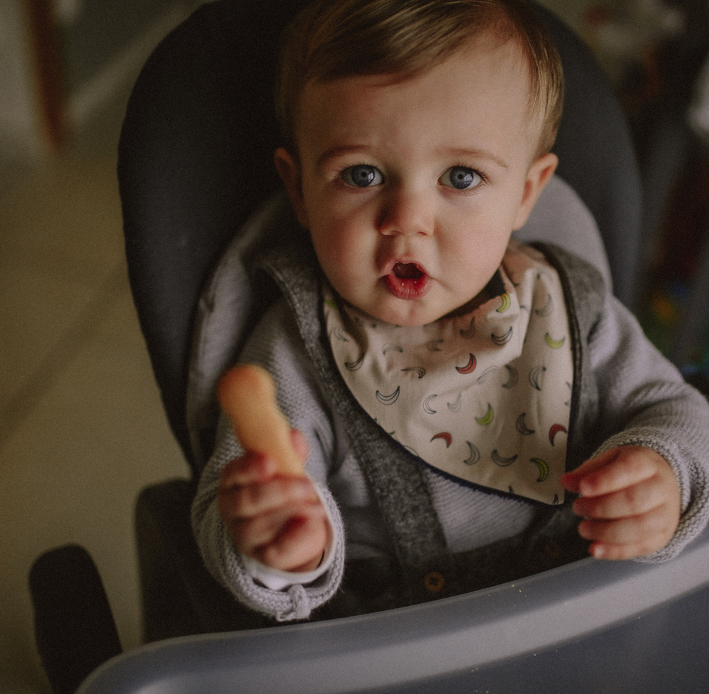 bébé porte un mini bavoir bandana pour les dents de bébé motif Banana fond beige Carotte & Cie