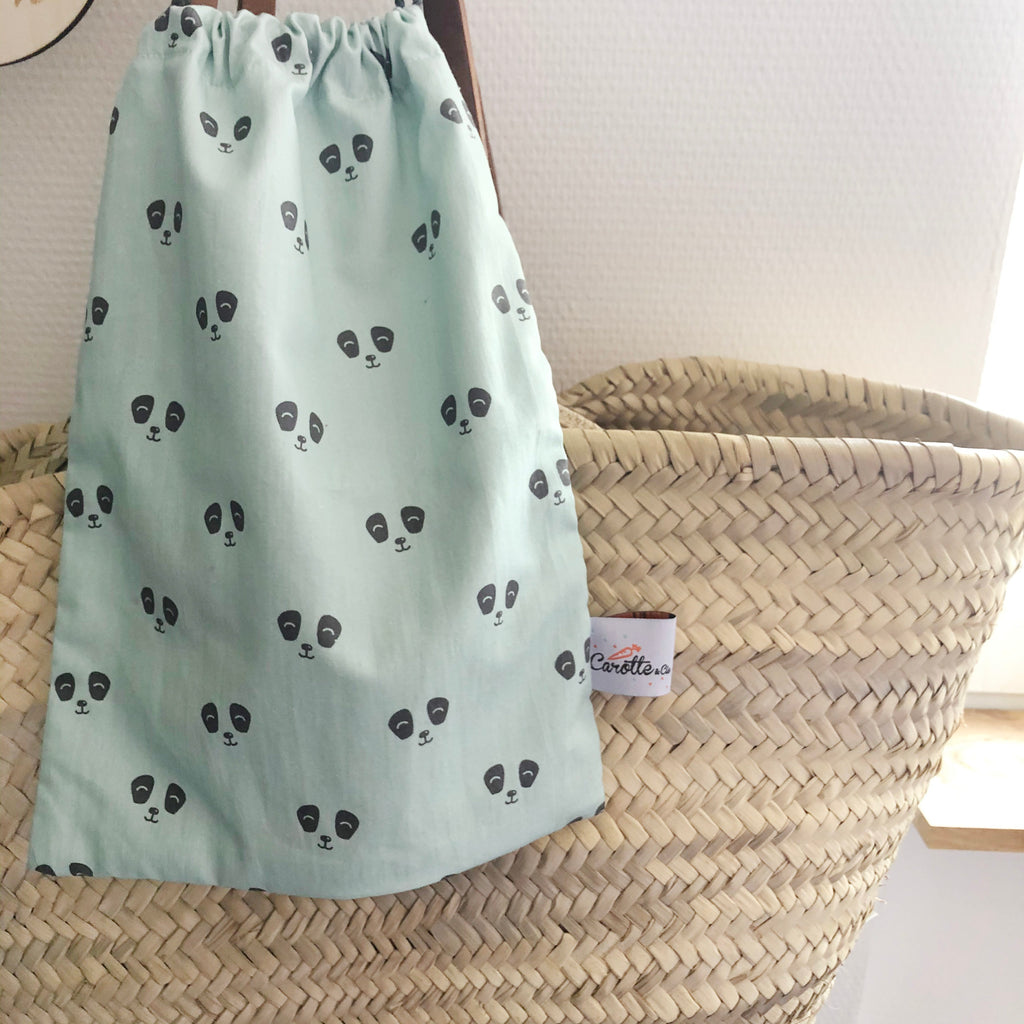 bébé range ses petites affaires dans son pochon en coton avec liens pour le goûter, le pyjama ou les jouets motif panda gris anthracite fond vert d'eau Carotte & Cie