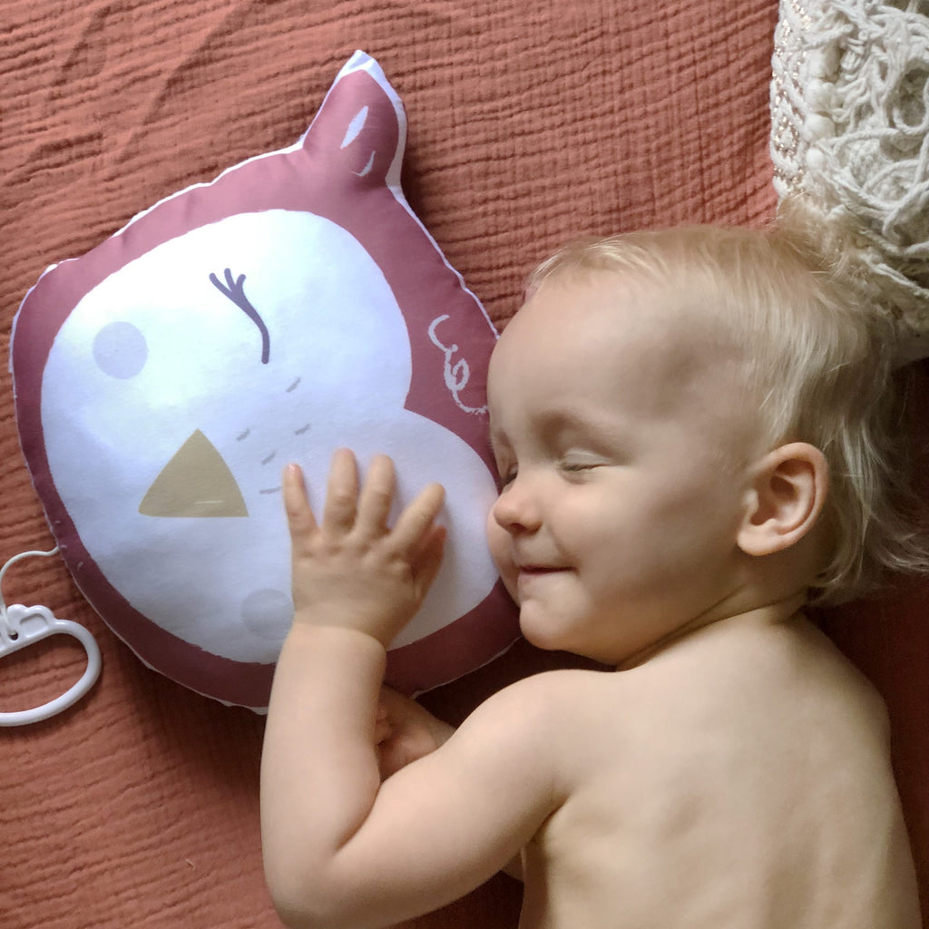 bébé jouant avec son coussin musical illustré motif exclusif tête de hibou rouge terracotta Carotte & Cie