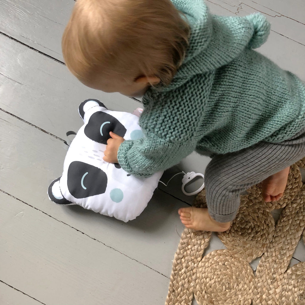 bébé jouant avec son coussin musical illustré motif exclusif tête de panda noir et blanc Carotte & Cie