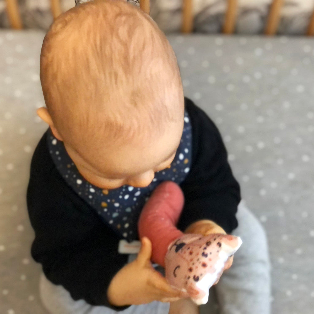 bébé porte un mini bavoir bandana pour les dents de bébé motif granite Terrazzo fond bleu marine Carotte & Cie